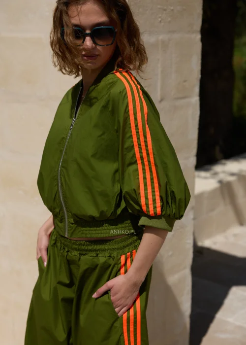 Khaki bluza dresowa bomberka z neonowymi koralowymi lampasami, krótszy fason na zamek z szerokimi rękawami i sportowym charakterem.