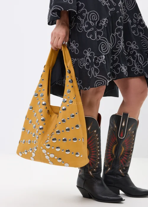 Musztardowa torebka shopper zdobiona srebrnymi nitami o różnych rozmiarach. Duży model na ramię z efektownymi metalicznymi detalami w rockowym stylu.