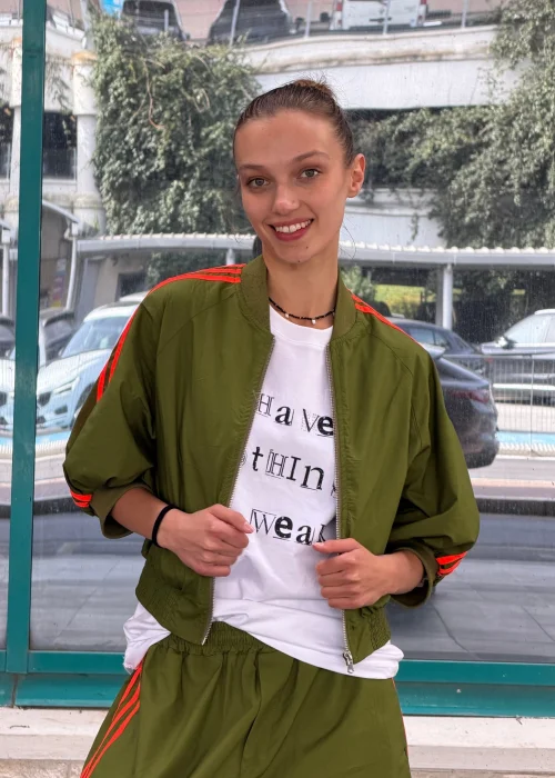 Khaki bluza dresowa bomberka z neonowymi koralowymi lampasami, krótszy fason na zamek z szerokimi rękawami i sportowym charakterem.