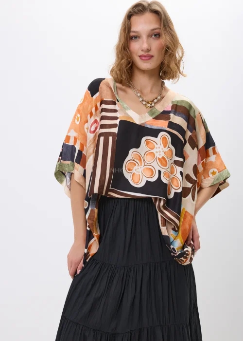 Wzorzysta bluzka oversize w geometryczny print w odcieniach beżu, czerni i pomarańczu, z luźnym rękawem, stylizowana w komplecie ze spódnicą w artystycznym looku.