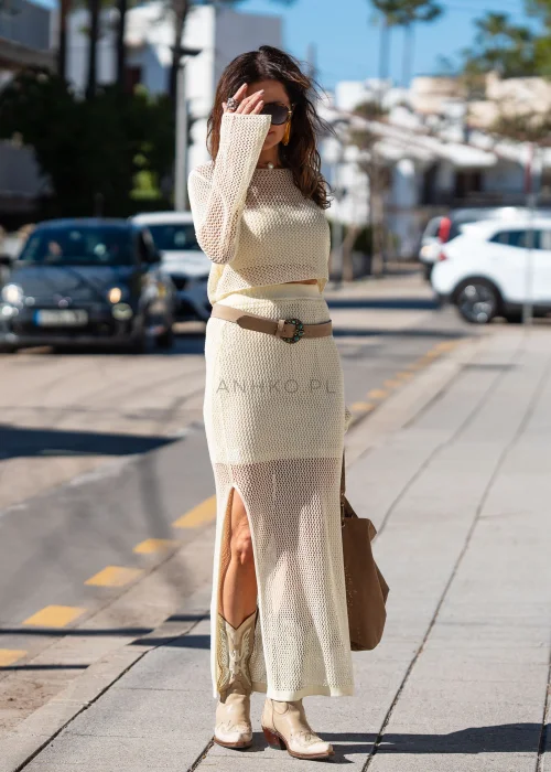 Śmietankowa ażurowa spódnica Crop maxi z siateczkowym splotem i krótszą podszewką. Lekko transparentny fason tworzy elegancką stylizację w stylu boho.