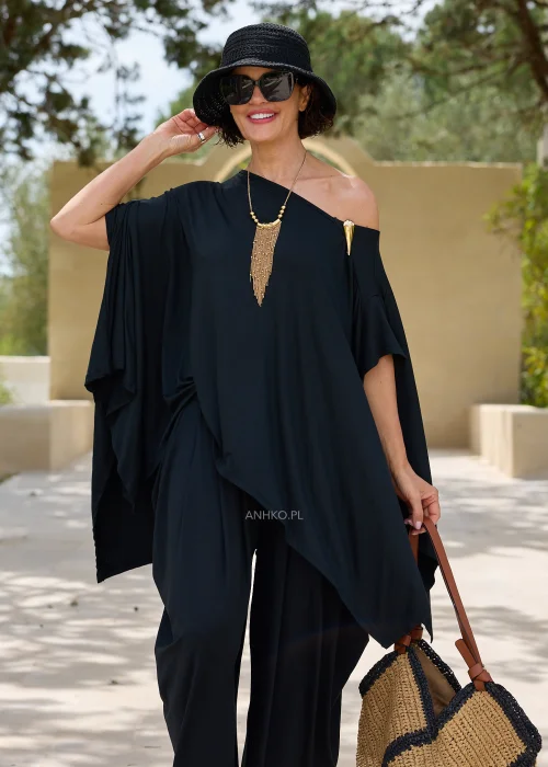 Czarna oversize’owa bluzka o asymetrycznym fasonie z efektownym dekoltem opadającym na jedno ramię. Zwiewny materiał i luźny krój tworzą elegancką, nowoczesną stylizację.
