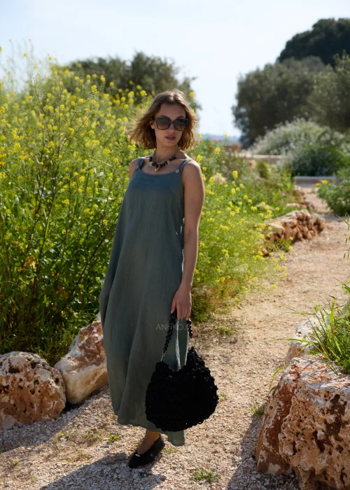 Oliwkowa lniana sukienka maxi na szerokich ramiączkach o luźnym, minimalistycznym kroju. Naturalna tkanina i swobodny fason tworzą ponadczasową stylizację w stylu boho i slow fashion.