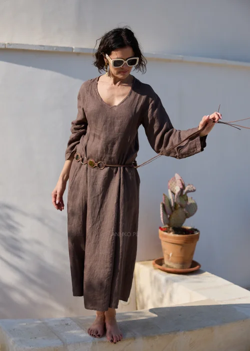 Brązowa lniana sukienka midi z dekoltem V i długimi rękawami o luźnym, naturalnym fasonie. Minimalistyczny krój podkreśla elegancję stylizacji w klimacie boho i slow fashion.