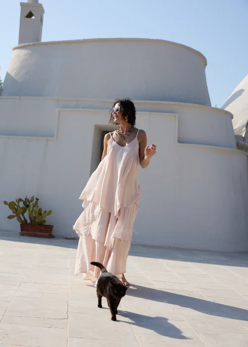 Pudroworóżowa sukienka maxi na cienkich ramiączkach z warstwowymi falbanami i luźnym, zwiewnym fasonem. Kobiecy model w stylu boho, idealny na wakacyjne stylizacje, spacery i letnie przyjęcia.