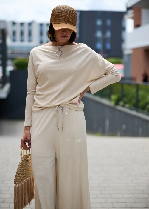 Pleciona czapka z daszkiem w kolorze camel wykonana z naturalnej rafii, ozdobiona dużą kokardą z tyłu, utrzymana w kobiecym stylu boho