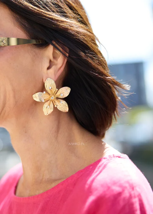 Duże złote kolczyki damskie w kształcie kwiatów z ozdobnymi kryształkami typu strass. Elegancka biżuteria glamour na wesele i wyjątkowe okazje.
