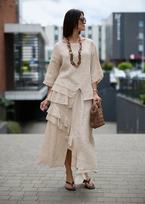Beżowa lniana bluzka o luźnym oversize'owym fasonie z okrągłym dekoltem, rękawami 3/4 i efektownymi asymetrycznymi falbanami z przodu.