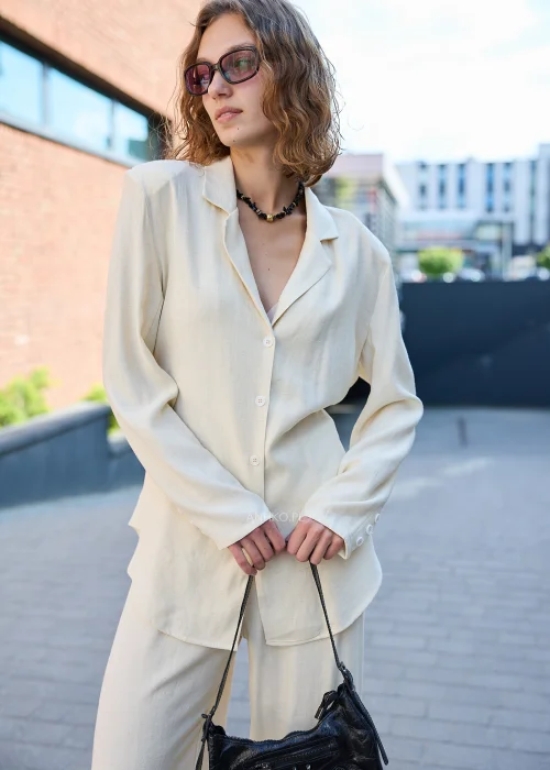 Damski elegancki komplet w kolorze ecru z marynarką zapinaną na guziki i szerokimi spodniami, idealny do nowoczesnych stylizacji casualowych i smart casual