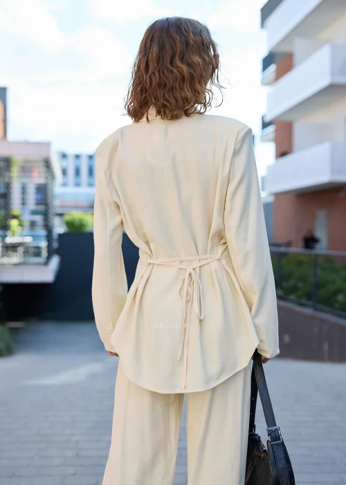 Damski elegancki komplet w kolorze ecru z marynarką zapinaną na guziki i szerokimi spodniami, idealny do nowoczesnych stylizacji casualowych i smart casual