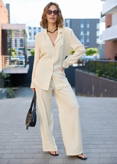 Damski elegancki komplet w kolorze ecru z marynarką zapinaną na guziki i szerokimi spodniami, idealny do nowoczesnych stylizacji casualowych i smart casual