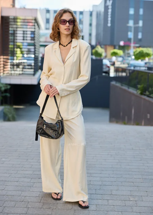 Damski elegancki komplet w kolorze ecru z marynarką zapinaną na guziki i szerokimi spodniami, idealny do nowoczesnych stylizacji casualowych i smart casual
