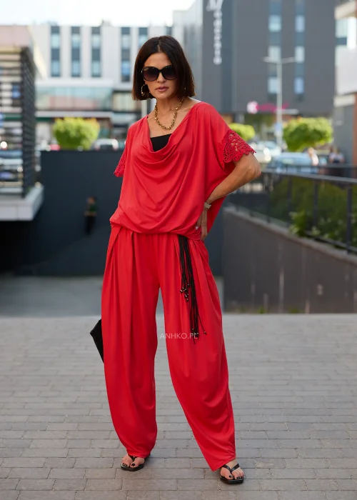 Czerwona bluzka damska oversize z drapowanym dekoltem i ażurowymi rękawami w eleganckiej stylizacji z czerwonymi spodniami