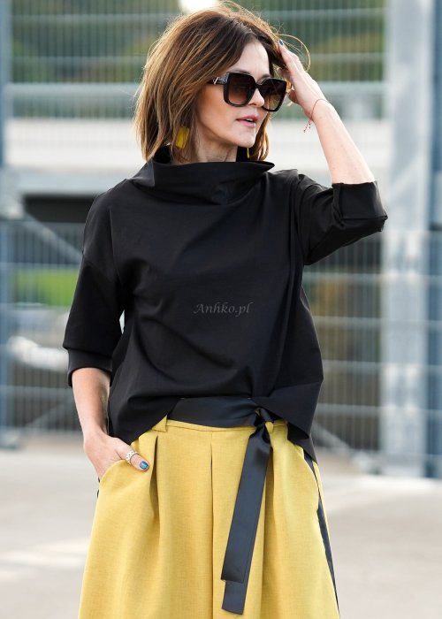 Czarna bluzka oversize z półgolfem i rękawem 3/4, stylizowana z szerokimi spodniami w kontrastowym kolorze w miejskim looku.