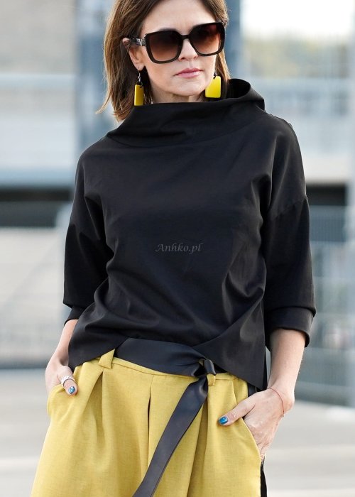 Czarna bluzka oversize z półgolfem i rękawem 3/4, stylizowana z szerokimi spodniami w kontrastowym kolorze w miejskim looku.